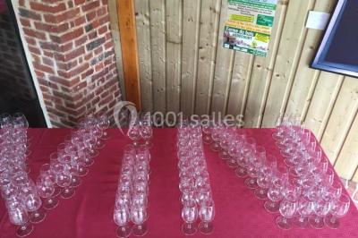 Un grand saule ombrageant un espace détente avec des palettes aménagées et des coussins sur une pelouse.