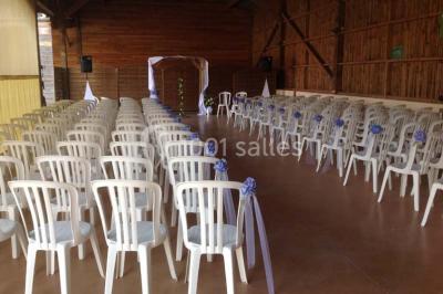 Un grand saule ombrageant un espace détente avec des palettes aménagées et des coussins sur une pelouse.