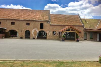 Un grand saule ombrageant un espace détente avec des palettes aménagées et des coussins sur une pelouse.