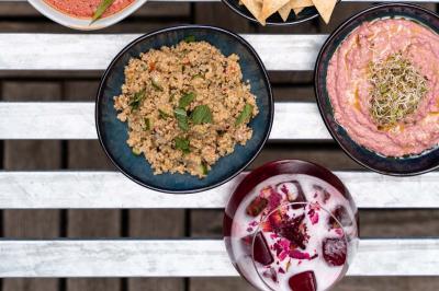 Un verre de jus vert, une brioche sur une assiette avec une cuillère, et une note manuscrite sur une table blanche.