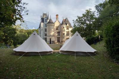 Un vélo décoré de fleurs blanches et vertes est appuyé contre une grille en fer forgé dans un cadre arboré.