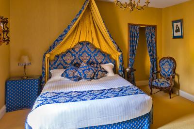 Un vélo décoré de fleurs blanches et vertes est appuyé contre une grille en fer forgé dans un cadre arboré.