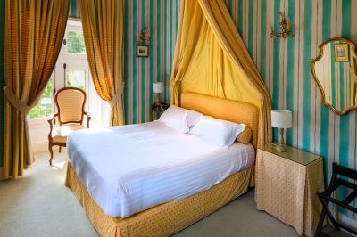 Un vélo décoré de fleurs blanches et vertes est appuyé contre une grille en fer forgé dans un cadre arboré.