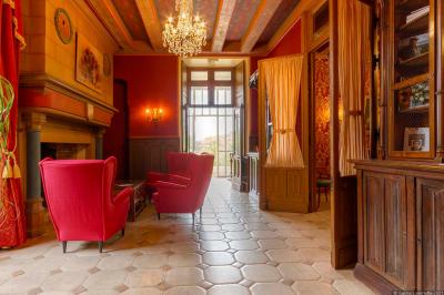 Un vélo décoré de fleurs blanches et vertes est appuyé contre une grille en fer forgé dans un cadre arboré.