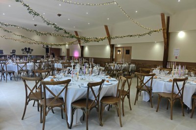 Un vélo décoré de fleurs blanches et vertes est appuyé contre une grille en fer forgé dans un cadre arboré.