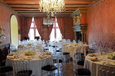 Un vélo décoré de fleurs blanches et vertes est appuyé contre une grille en fer forgé dans un cadre arboré.