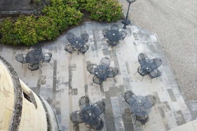 Un vélo décoré de fleurs blanches et vertes est appuyé contre une grille en fer forgé dans un cadre arboré.