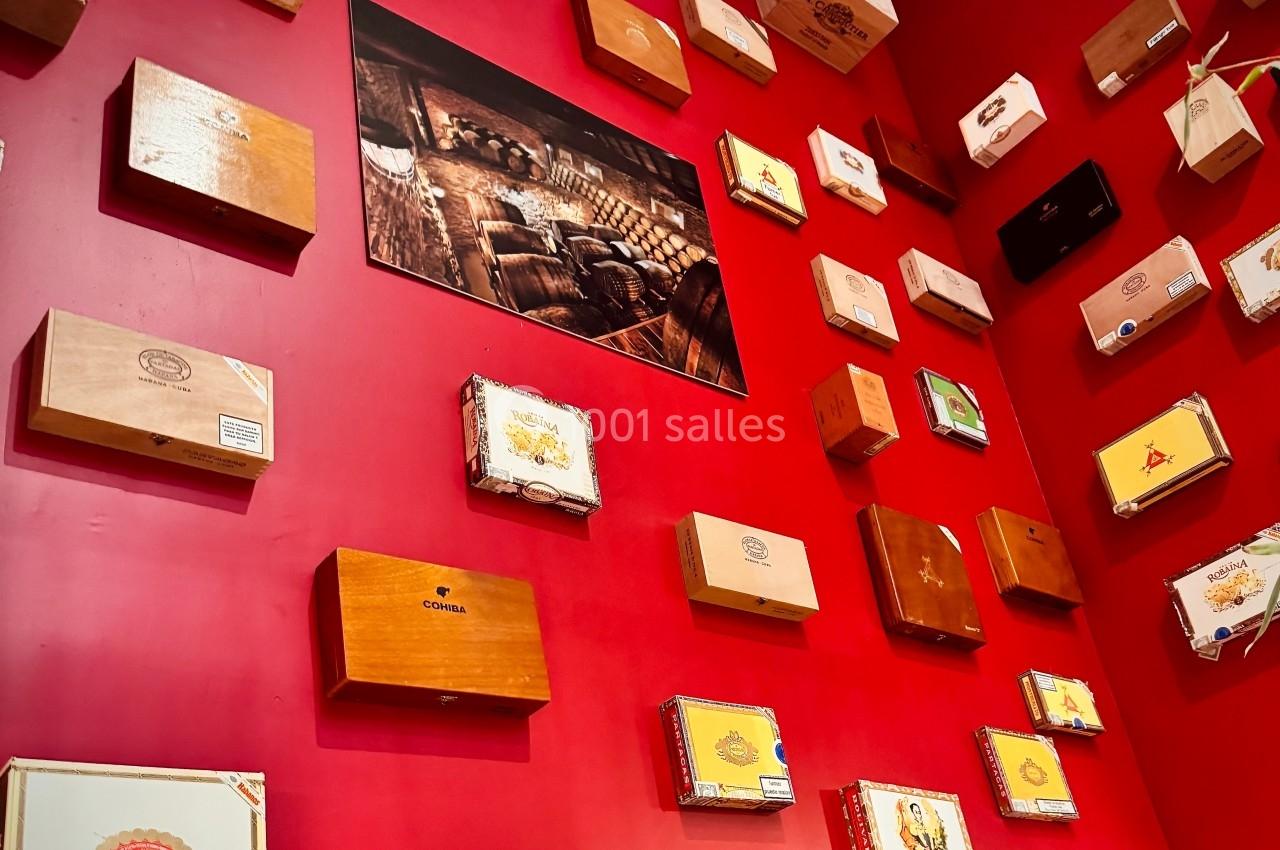 Mur rouge décoré de boîtes en bois de différentes tailles et motifs, avec un cadre photo au centre.