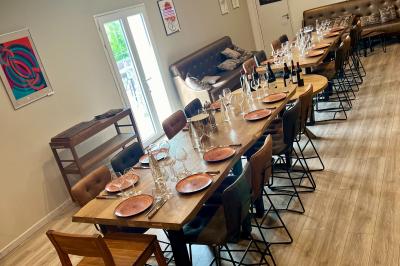 Coucher de soleil rougeoyant derrière une rangée d'arbres, vu depuis une terrasse avec mobilier et voitures garées.