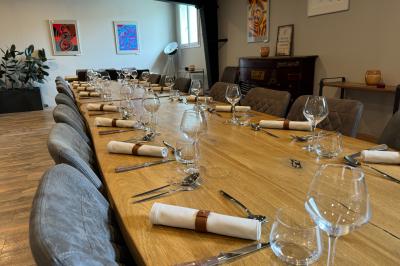 Coucher de soleil rougeoyant derrière une rangée d'arbres, vu depuis une terrasse avec mobilier et voitures garées.