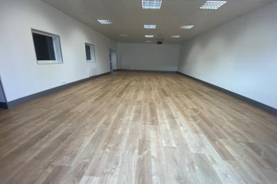 Cuisine professionnelle avec carrelage mural coloré, réfrigérateur, distributeur d'eau et équipements en inox.