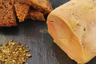 Plateau de légumes croquants, dips et charcuterie disposés sur une table en extérieur, avec des décorations végétales.