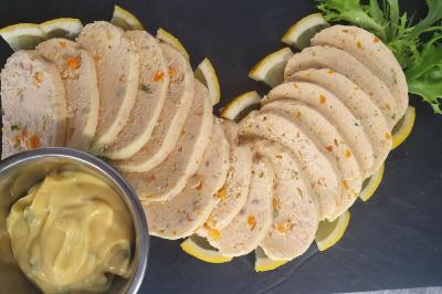 Plateau de légumes croquants, dips et charcuterie disposés sur une table en extérieur, avec des décorations végétales.