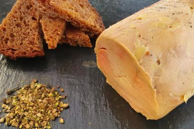 Plateau de légumes croquants, dips et charcuterie disposés sur une table en extérieur, avec des décorations végétales.
