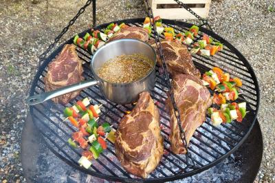 Plateau de légumes croquants, dips et charcuterie disposés sur une table en extérieur, avec des décorations végétales.