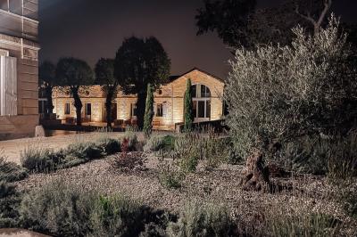 Une mariée en robe blanche et un marié en costume vert posent sur une voiture ancienne dans un cadre extérieur ensoleillé.