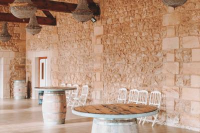 Une mariée en robe blanche et un marié en costume vert posent sur une voiture ancienne dans un cadre extérieur ensoleillé.