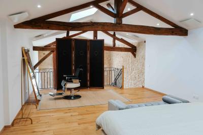 Une mariée en robe blanche et un marié en costume vert posent sur une voiture ancienne dans un cadre extérieur ensoleillé.