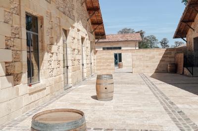 Une mariée en robe blanche et un marié en costume vert posent sur une voiture ancienne dans un cadre extérieur ensoleillé.