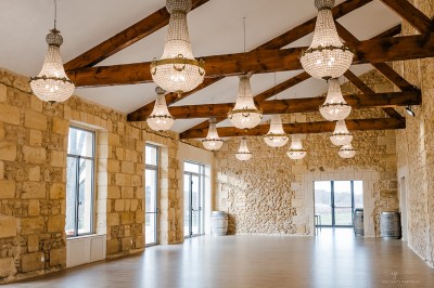 Miniature Salle de séminaire - ©instants-partagés Façade d'un bâtiment en pierre avec grandes baies vitrées illuminées par des lumières roses à la tombée de la nuit.