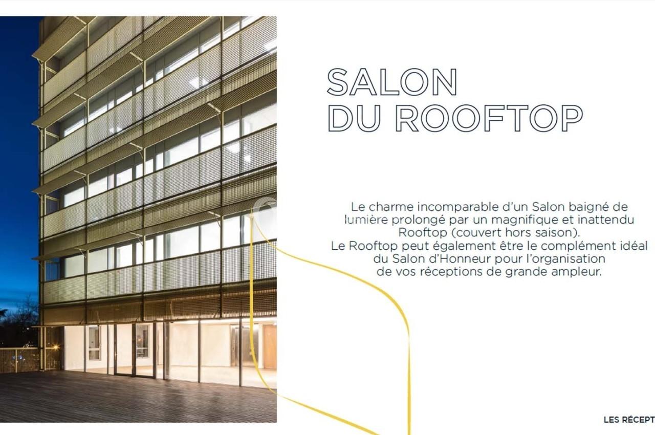 Vue d'un bâtiment moderne éclairé de nuit avec une terrasse en hauteur et un texte descriptif à droite.