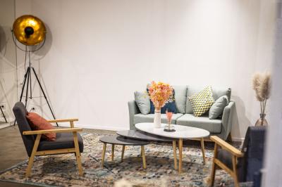 Salle lumineuse avec verrière, murs blancs, sol clair et mobilier minimaliste comprenant une table basse et un fauteuil.