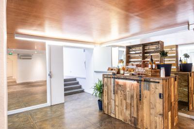 Salle lumineuse avec verrière, murs blancs, sol clair et mobilier minimaliste comprenant une table basse et un fauteuil.