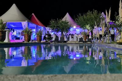 Façade d'un bâtiment illuminée par des projections lumineuses colorées dans un environnement nocturne.