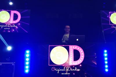 Façade d'un bâtiment illuminée par des projections lumineuses colorées dans un environnement nocturne.