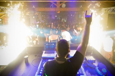 Façade d'un bâtiment illuminée par des projections lumineuses colorées dans un environnement nocturne.