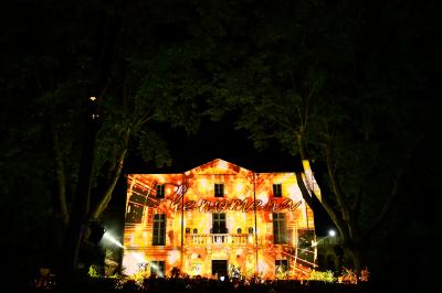 Façade d'un bâtiment illuminée par des projections lumineuses colorées dans un environnement nocturne.