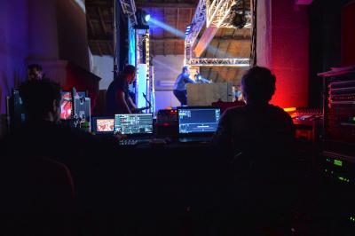 Façade d'un bâtiment illuminée par des projections lumineuses colorées dans un environnement nocturne.