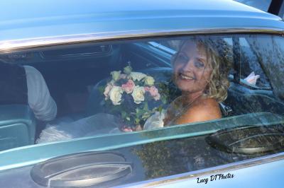 Femme en peignoir blanc se maquillant devant un miroir, ses cheveux ornés de petites fleurs blanches.