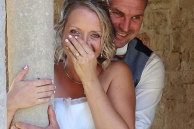 Femme en peignoir blanc se maquillant devant un miroir, ses cheveux ornés de petites fleurs blanches.