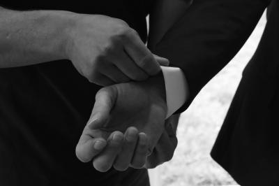 Femme en peignoir blanc se maquillant devant un miroir, ses cheveux ornés de petites fleurs blanches.