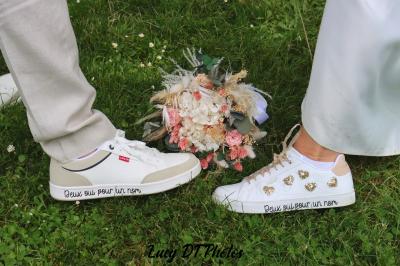 Femme en peignoir blanc se maquillant devant un miroir, ses cheveux ornés de petites fleurs blanches.