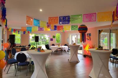 Musiciens mariachi jouant de la trompette, de la guitare et du violon dans une salle décorée de couleurs vives et de…