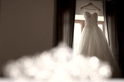 Deux alliances en métal, dont une ornée de petits diamants, posées sur un tissu noir avec un fond flou.