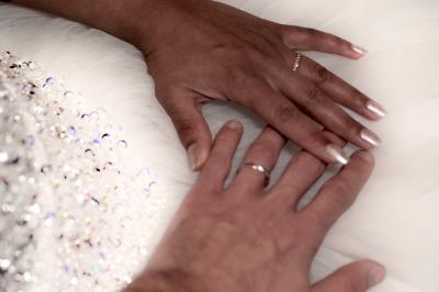 Deux alliances en métal, dont une ornée de petits diamants, posées sur un tissu noir avec un fond flou.