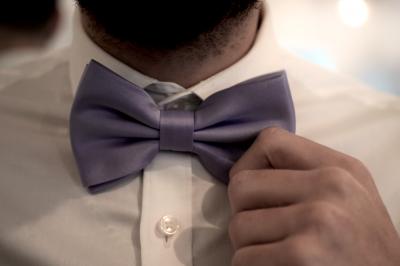 Deux alliances en métal, dont une ornée de petits diamants, posées sur un tissu noir avec un fond flou.