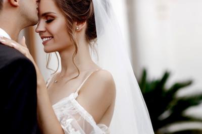 Deux alliances en métal, dont une ornée de petits diamants, posées sur un tissu noir avec un fond flou.