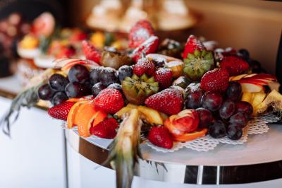 Cuisine professionnelle avec plans de travail en inox, réfrigérateurs, sol en bois clair et murs carrelés gris.