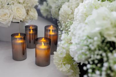 Cuisine professionnelle avec plans de travail en inox, réfrigérateurs, sol en bois clair et murs carrelés gris.