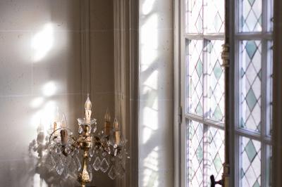 Cuisine professionnelle avec plans de travail en inox, réfrigérateurs, sol en bois clair et murs carrelés gris.