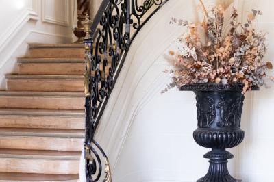 Cuisine professionnelle avec plans de travail en inox, réfrigérateurs, sol en bois clair et murs carrelés gris.