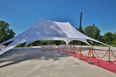 Cuisine professionnelle avec plans de travail en inox, réfrigérateurs, sol en bois clair et murs carrelés gris.