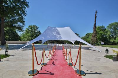 Cuisine professionnelle avec plans de travail en inox, réfrigérateurs, sol en bois clair et murs carrelés gris.