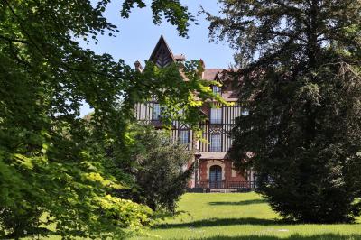 Cuisine professionnelle avec plans de travail en inox, réfrigérateurs, sol en bois clair et murs carrelés gris.