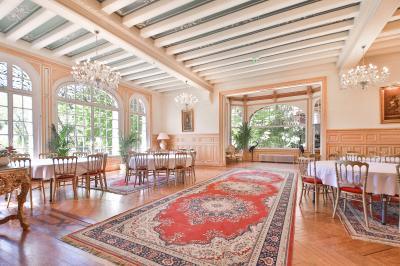 Cuisine professionnelle avec plans de travail en inox, réfrigérateurs, sol en bois clair et murs carrelés gris.