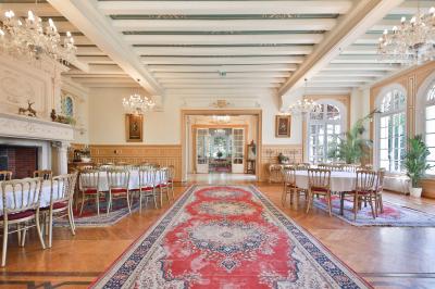 Cuisine professionnelle avec plans de travail en inox, réfrigérateurs, sol en bois clair et murs carrelés gris.